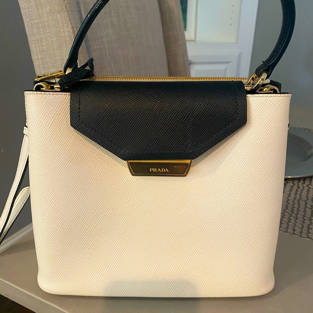 Prada Cartella white and black bag. Three large  interior clean pockets.